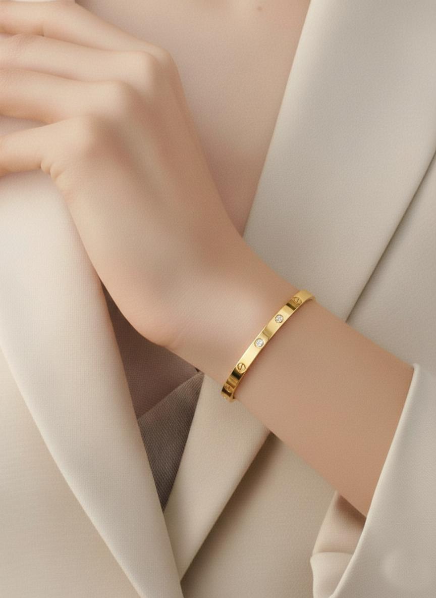 Cartier Love bracelet with small stones on a person's wrist against a neutral background